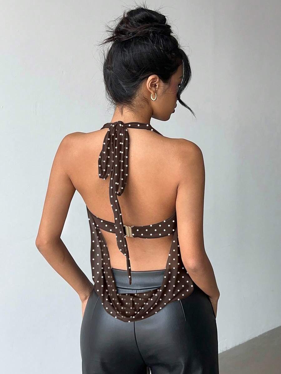 Brown and white polka dot semi-sheer halter camisole top with a plunging neckline, backless design, draped front, and metallic studded embellishments.