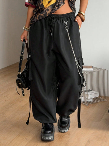 Black plus size cargo pants with drawstring waist and chain accent on loose-fit woven fabric.