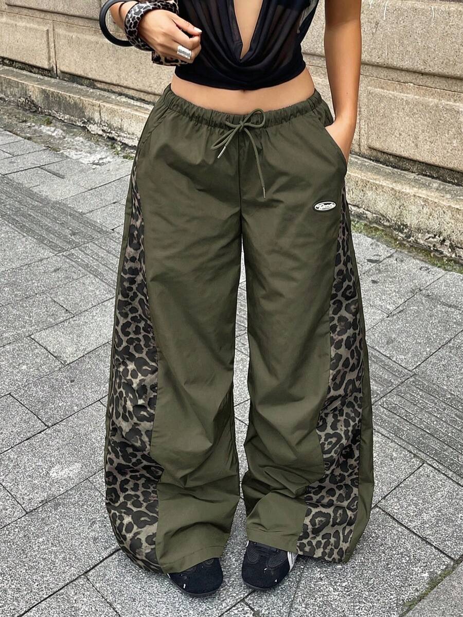 Women's black baggy jogger pants with an adjustable drawstring waist and colorblock polka dot geometric pattern.