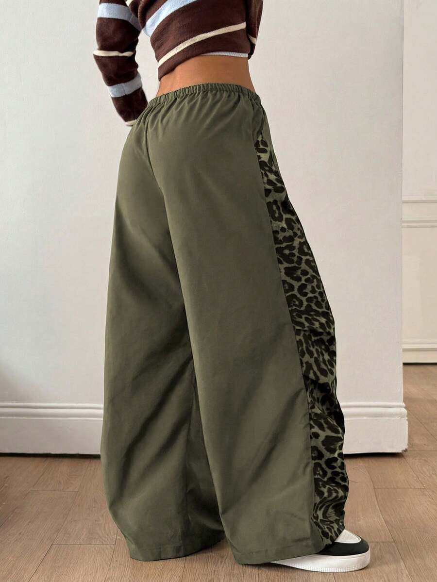 Women's black baggy jogger pants with an adjustable drawstring waist and colorblock polka dot geometric pattern.