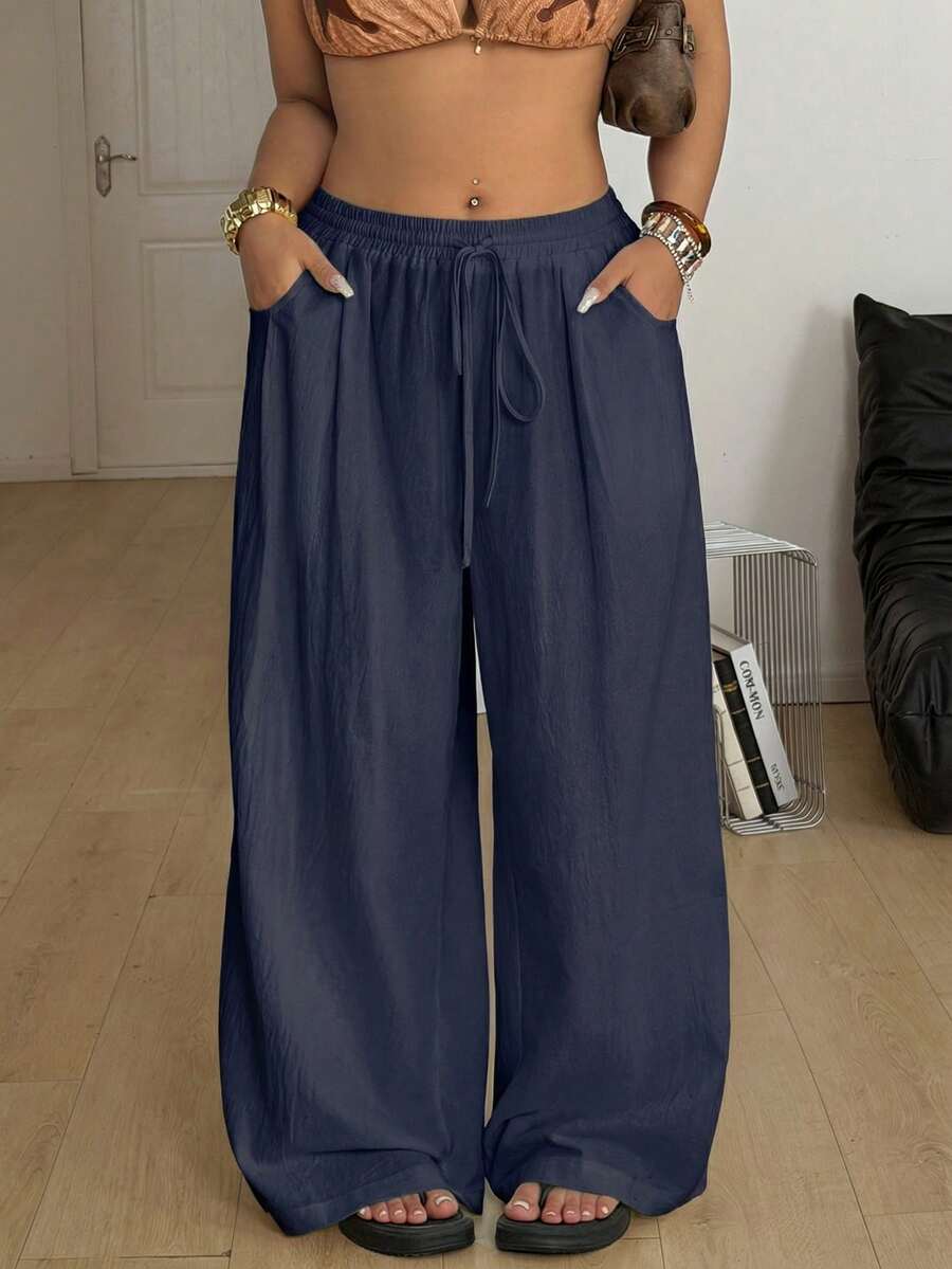 Women's loose straight leg cotton pants featuring a high waist with an adjustable drawstring knot and functional side pockets.
