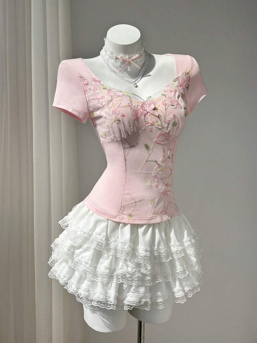 Women's pink short sleeve slim fit dress featuring a plant pattern, scoop neck, ruched appliques, and button front detail.