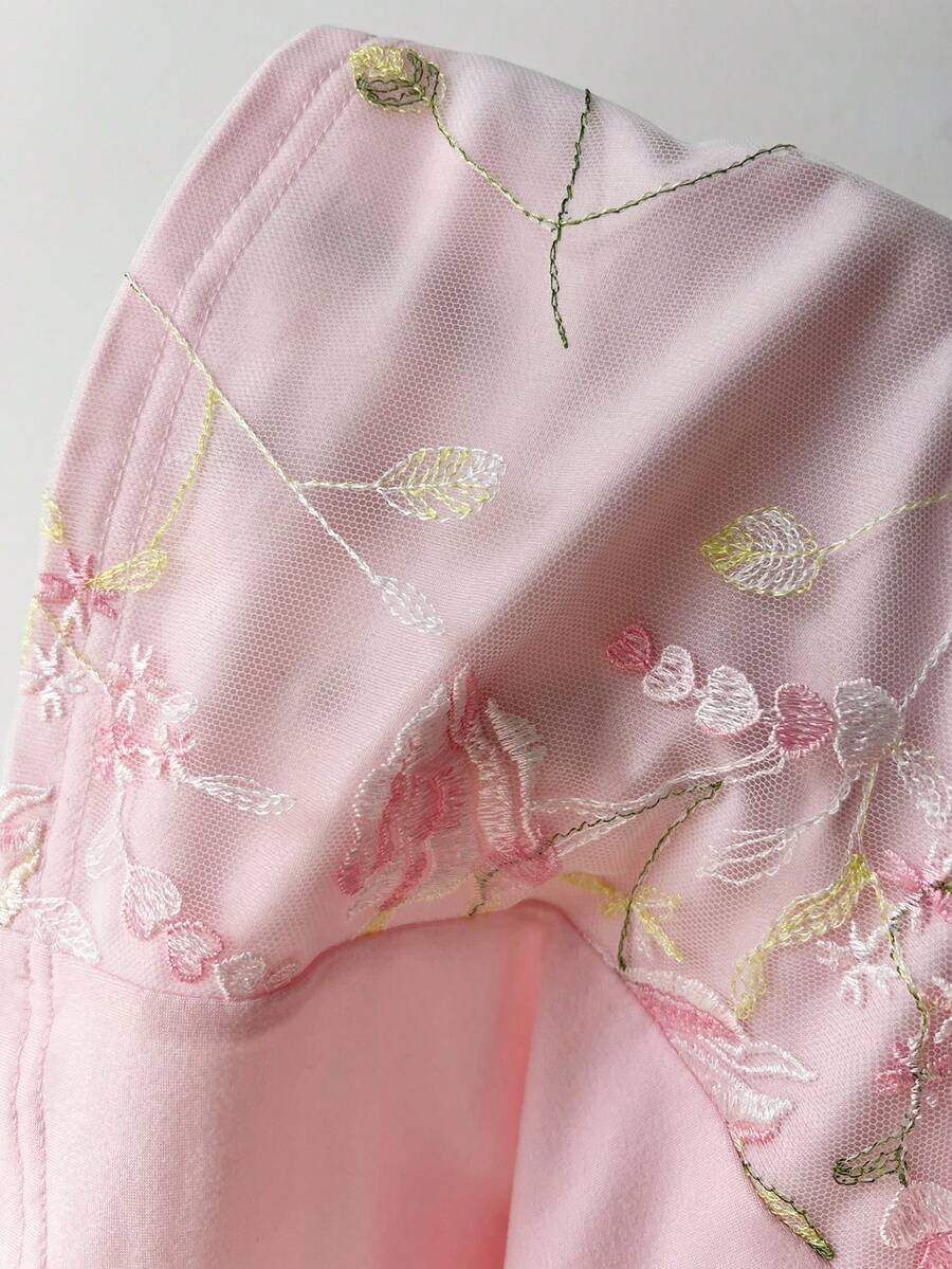 Women's pink short sleeve slim fit dress featuring a plant pattern, scoop neck, ruched appliques, and button front detail.