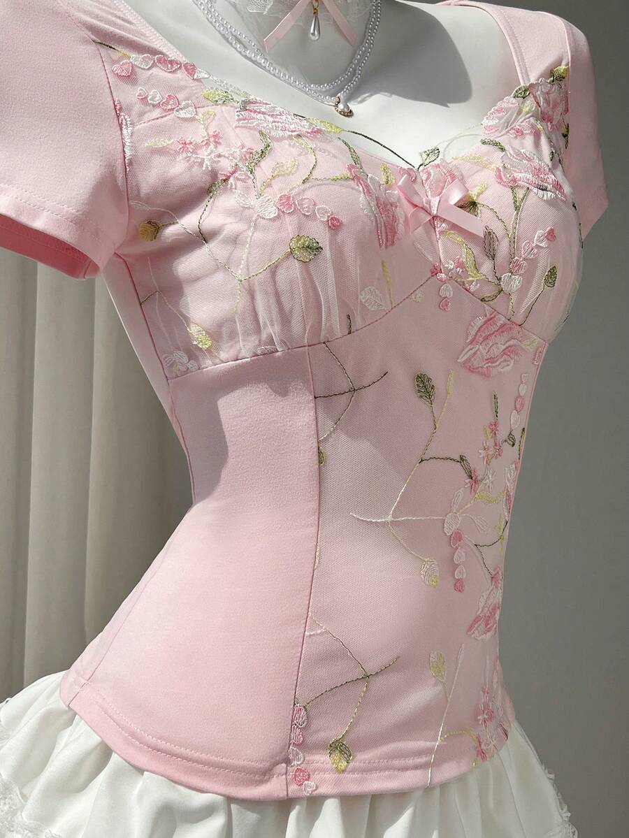 Women's pink short sleeve slim fit dress featuring a plant pattern, scoop neck, ruched appliques, and button front detail.