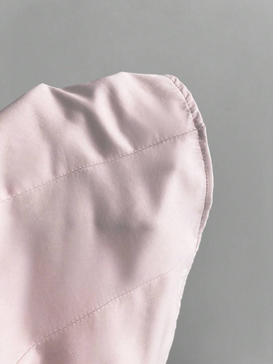 Women's black 2-in-1 blouse featuring a sweetheart neckline, short puff sleeves, front tie bow accent, and asymmetrical hem.