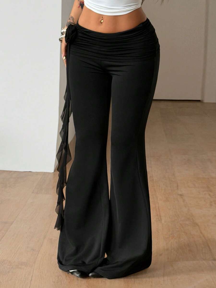 Black low waist flare pants featuring 3D rose and side stripe detailing in stretchy mesh fabric.