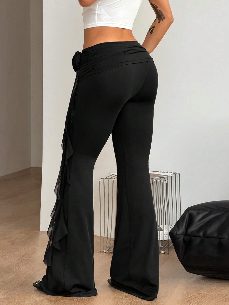 Black low waist flare pants featuring 3D rose and side stripe detailing in stretchy mesh fabric.