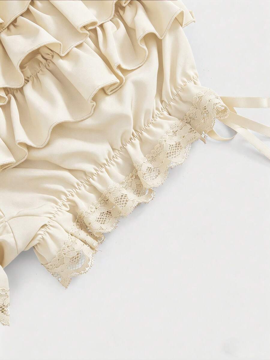 Women's tiered ruffle skort shorts featuring an elastic mid waist with front tie knot detail in woven fabric.