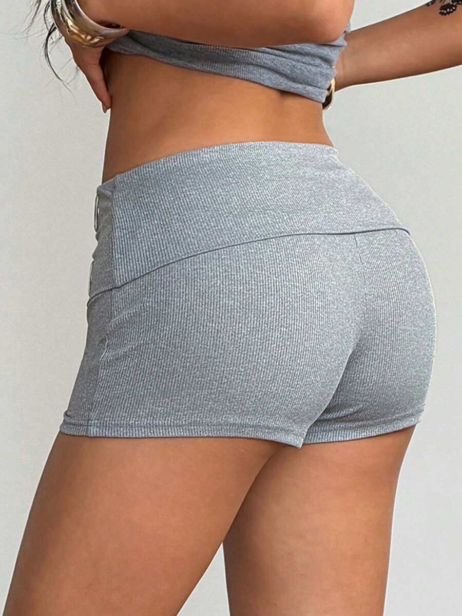 Women's light grey low waist track shorts with belted detail, zipper fly, and grommet eyelet accents