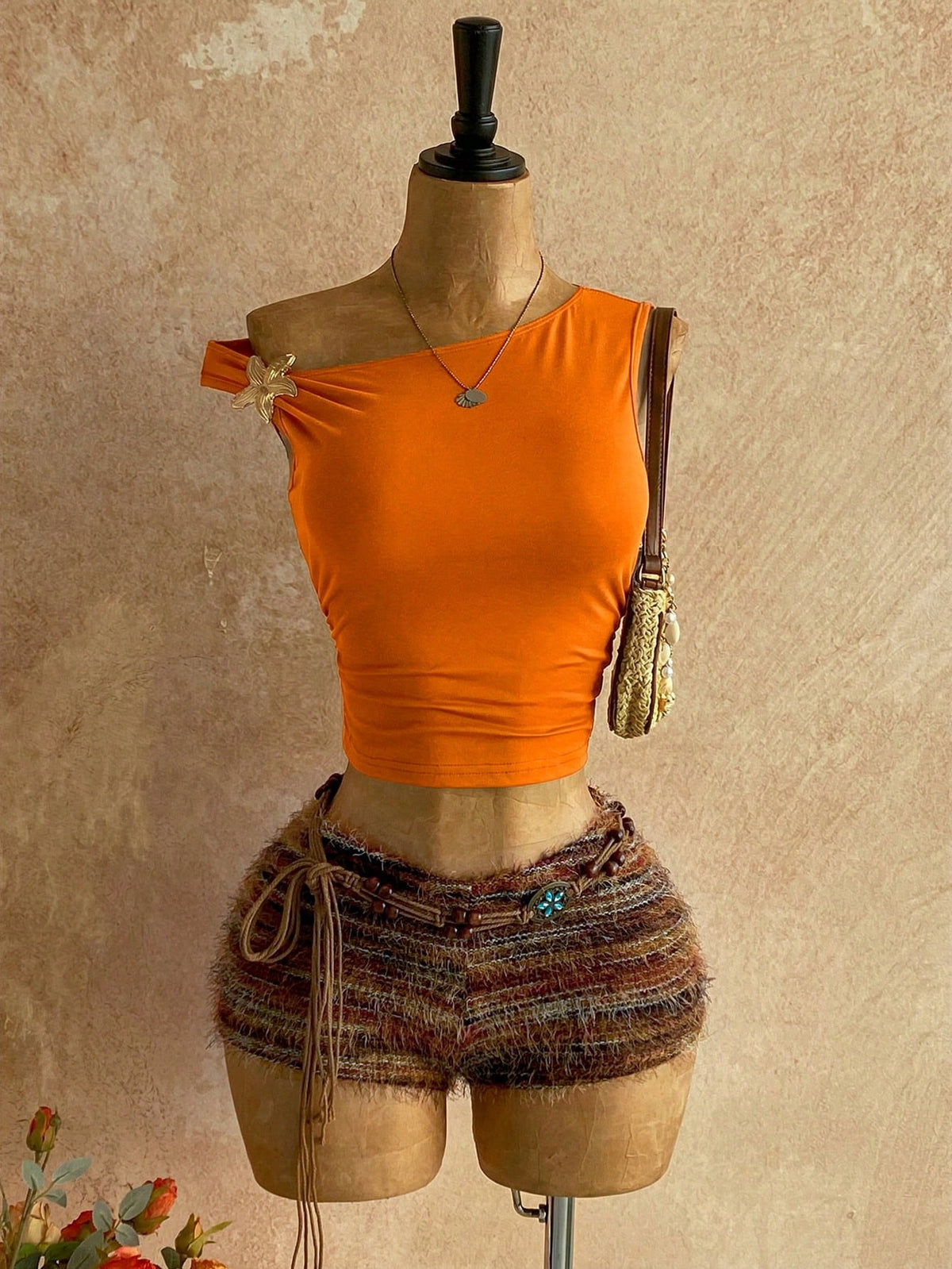Women's black fuzzy knit two-piece set with an asymmetrical crop camisole top featuring ruched detail and cutout back, paired with matching mini shorts.