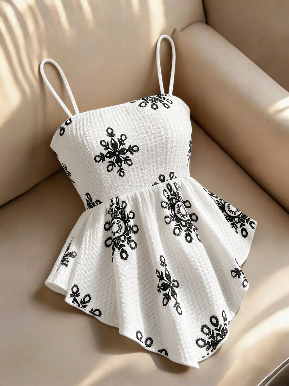 Women's floral snowflake print camisole top featuring spaghetti straps, slim fit, and an asymmetrical hem in navy blue knit fabric.