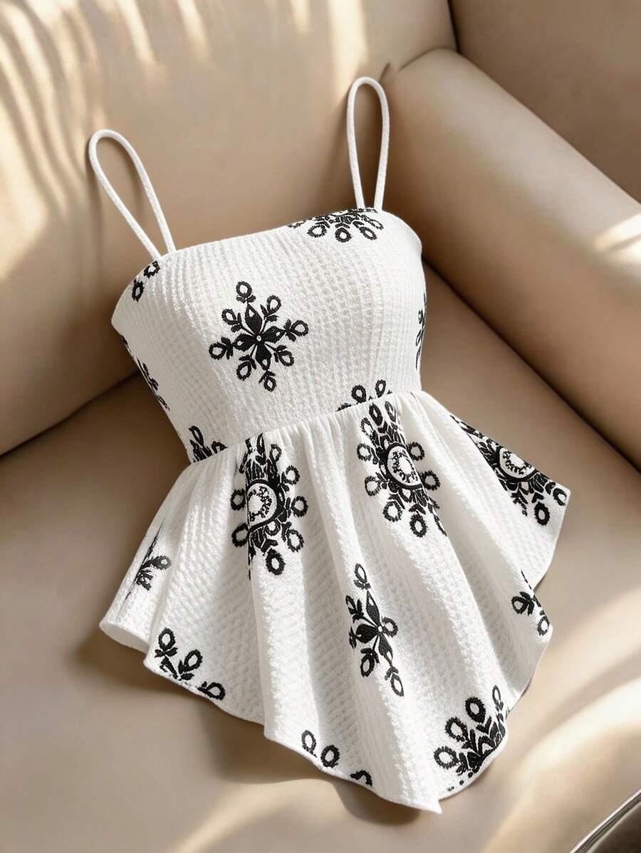 Women's floral snowflake print camisole top featuring spaghetti straps, slim fit, and an asymmetrical hem in navy blue knit fabric.