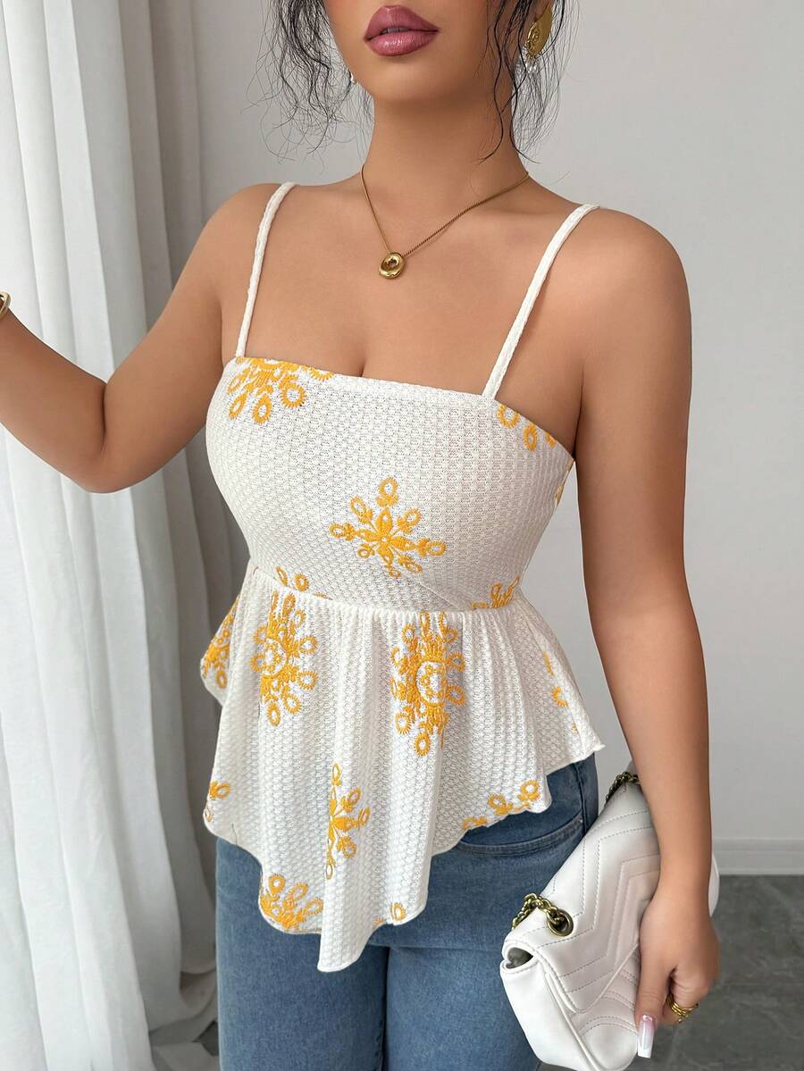Women's floral snowflake print camisole top featuring spaghetti straps, slim fit, and an asymmetrical hem in navy blue knit fabric.
