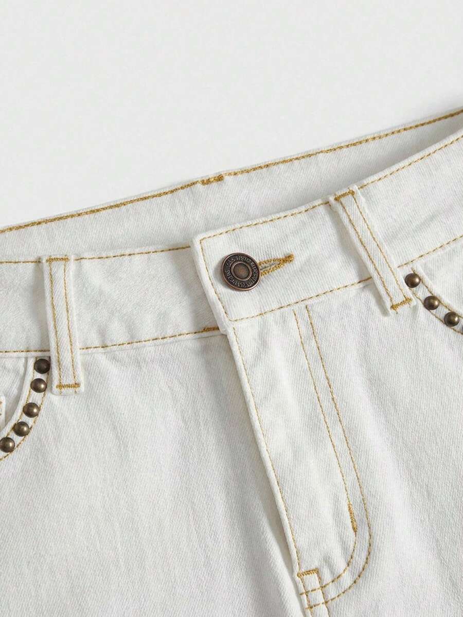 Women's Y2K low waist distressed shorts featuring butterfly studded details, pockets, and a zipper fly closure.