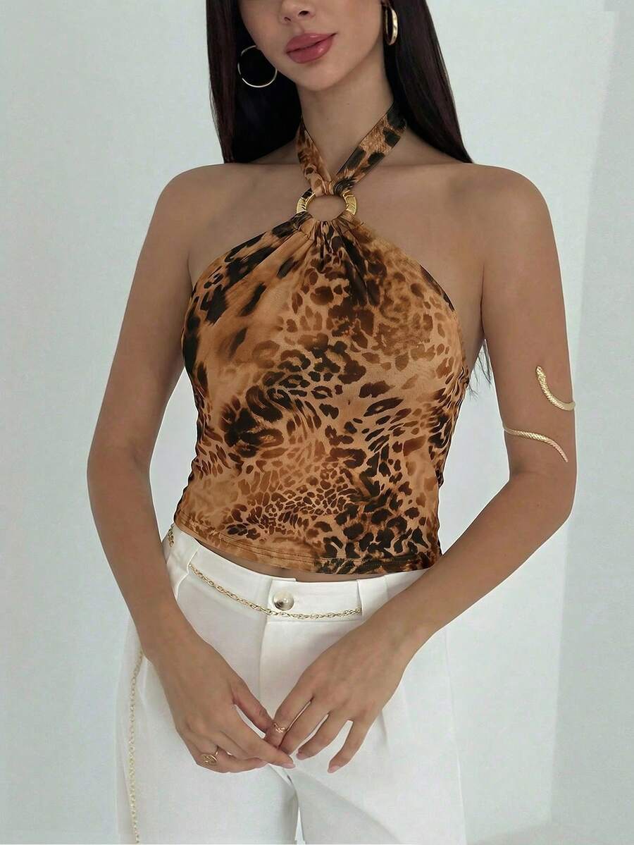 Women's black backless halter mesh crop top featuring knot and ring details with matching arm sleeves.