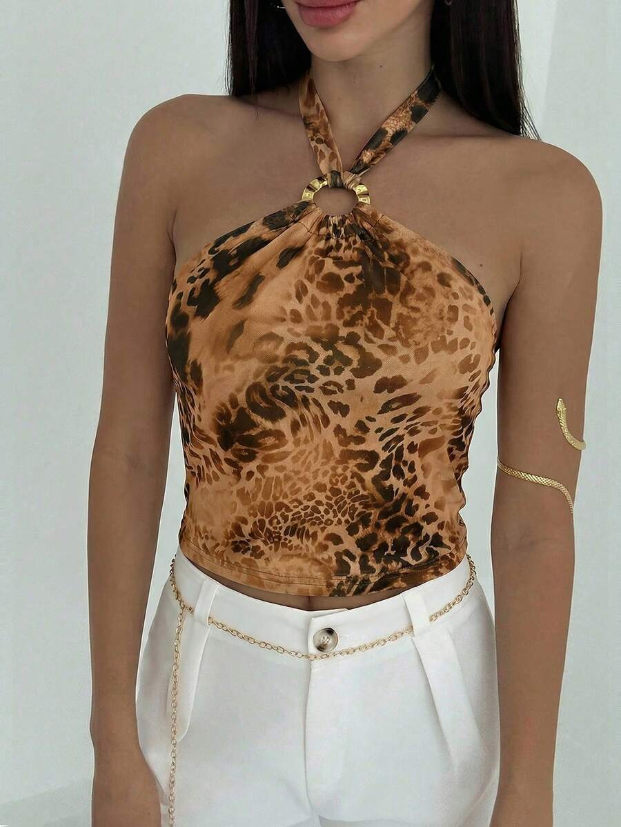Women's black backless halter mesh crop top featuring knot and ring details with matching arm sleeves.
