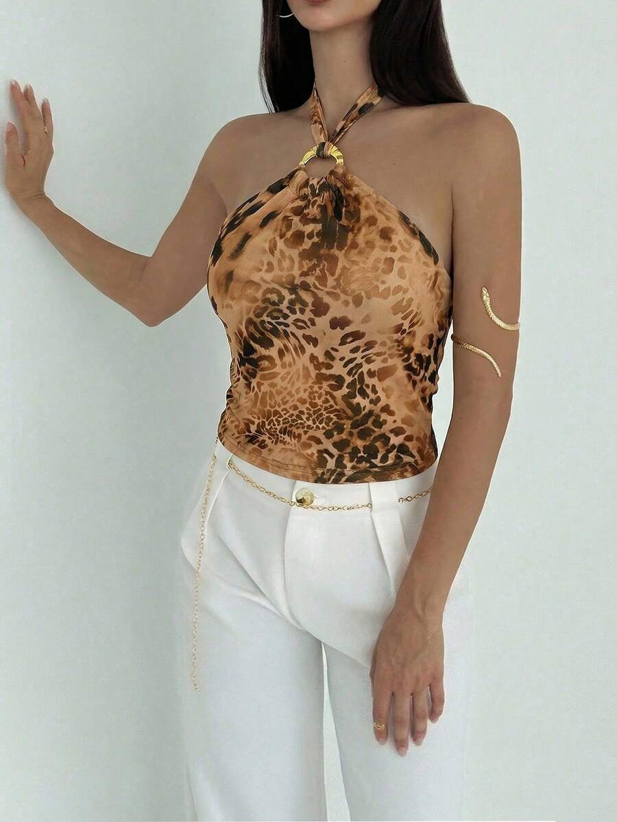 Women's black backless halter mesh crop top featuring knot and ring details with matching arm sleeves.