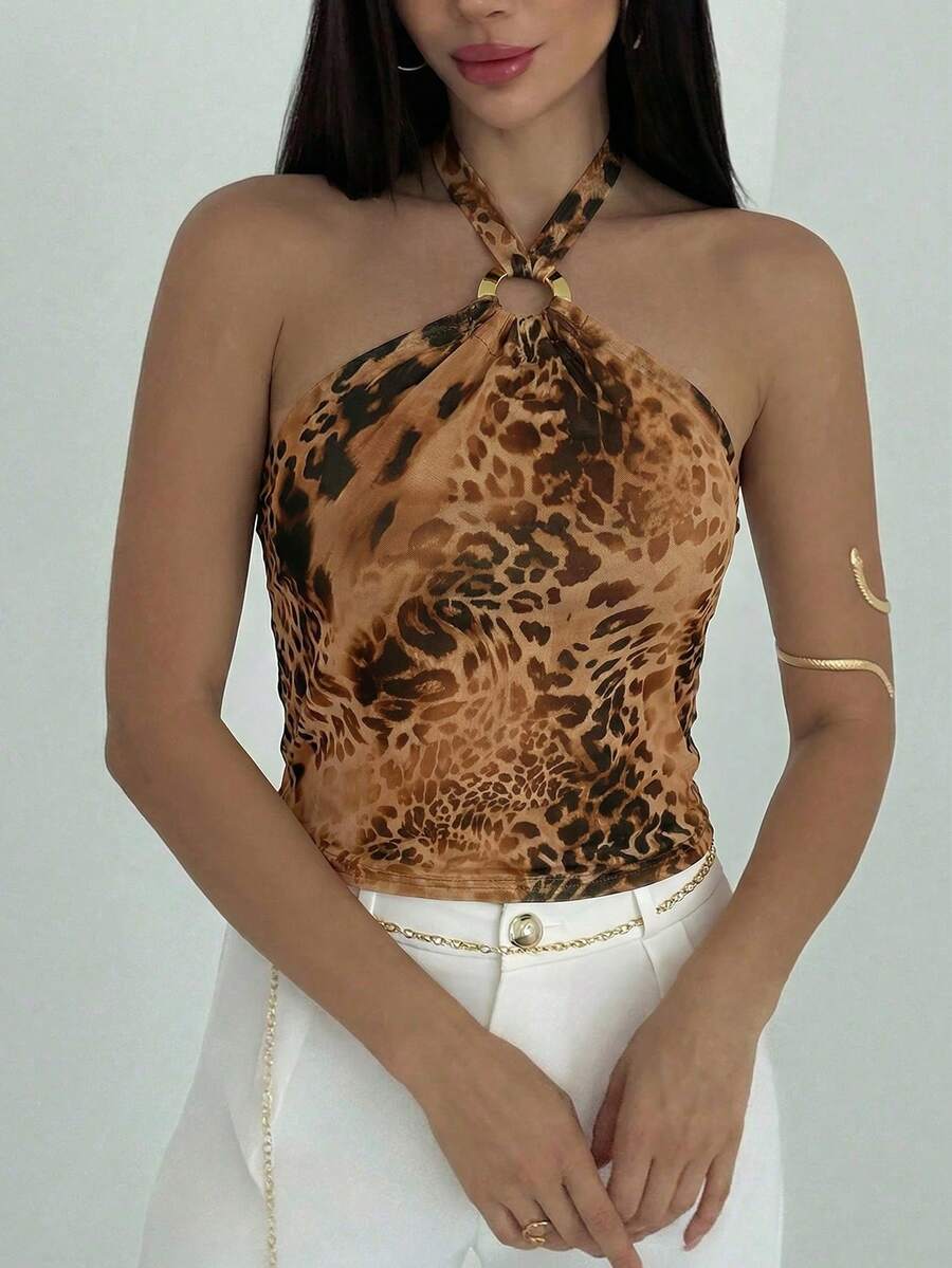 Women's black backless halter mesh crop top featuring knot and ring details with matching arm sleeves.