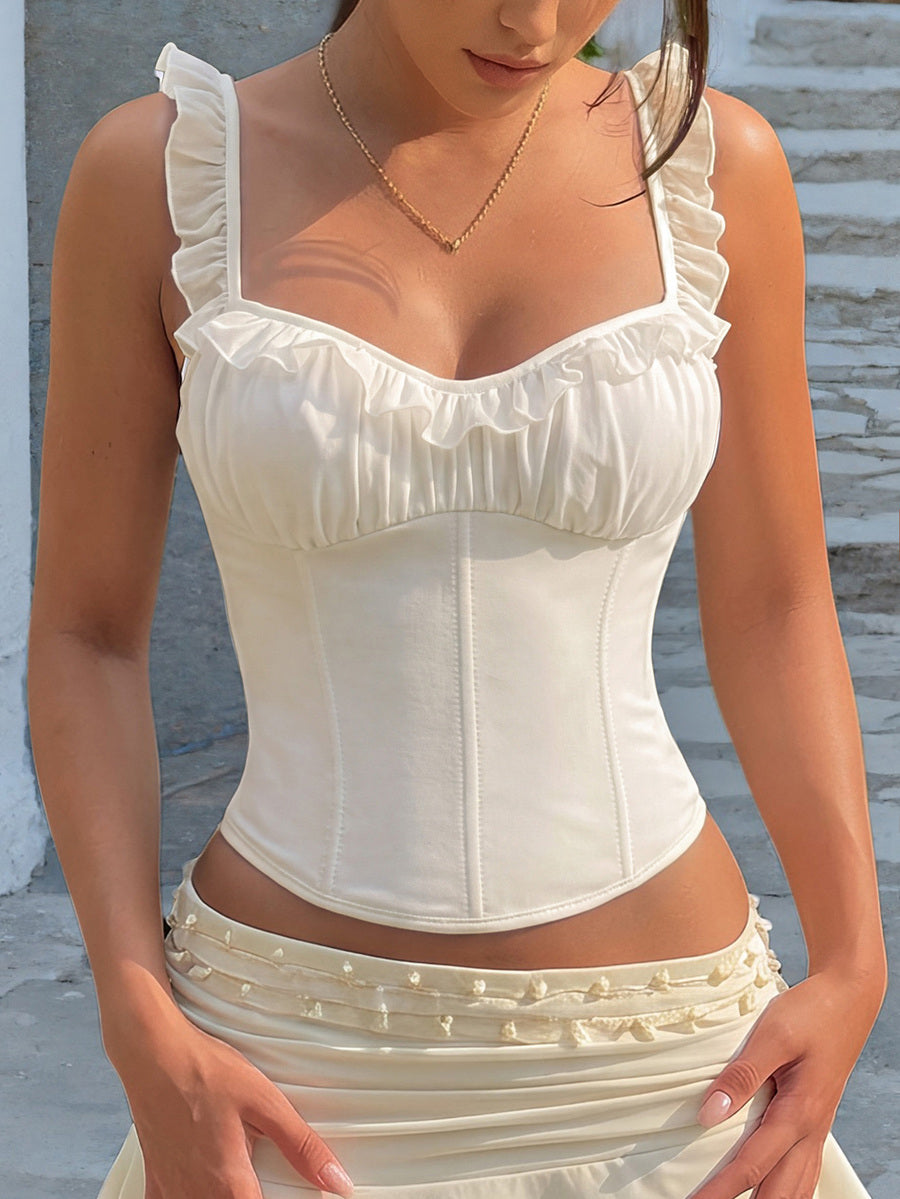 White cropped slim fit camisole top featuring ruffle lettuce trim, lace-up detail, and square neckline.