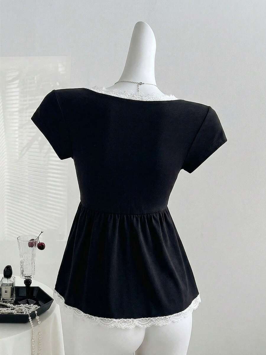 Slim fit Y2K t-shirt featuring contrast lace trim, an overlap collar, belted knot detail, cap raglan sleeves, and a flared hem.