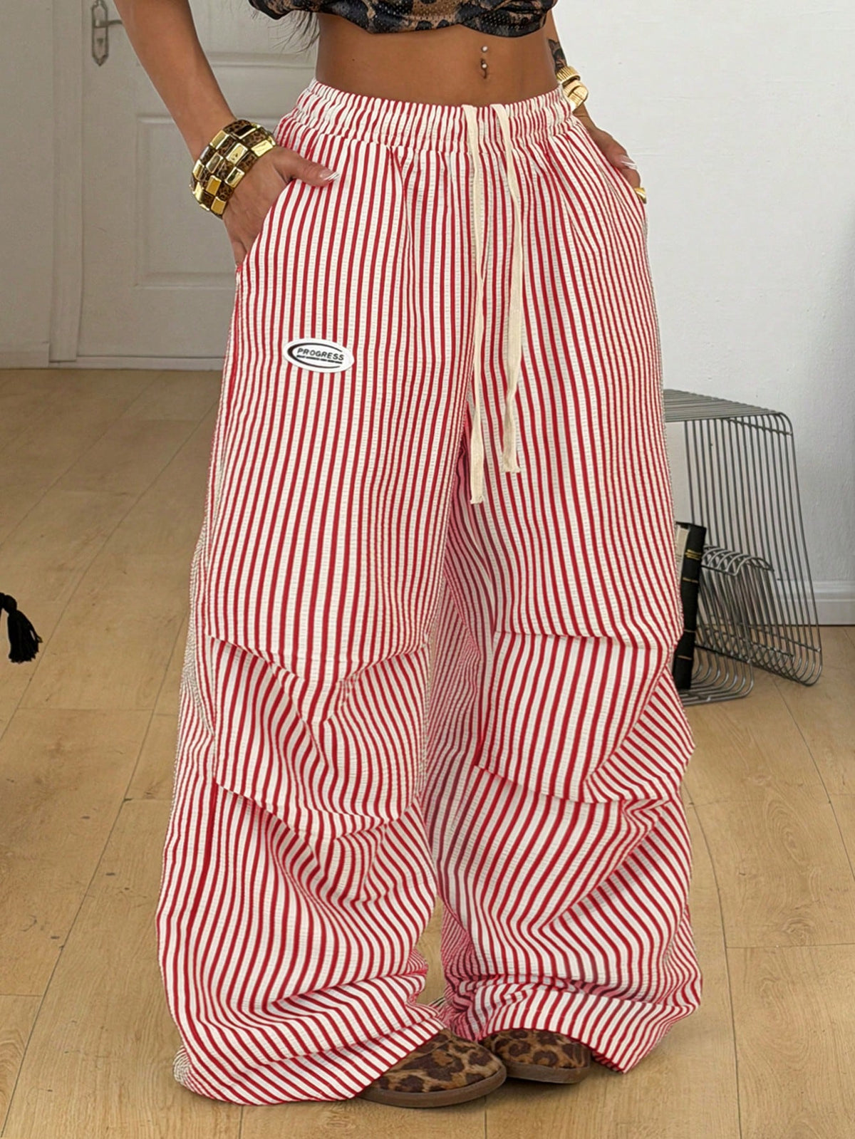 Women's black and white striped wide leg pants featuring an elastic drawstring waistband, side pockets, and a loose straight leg fit.