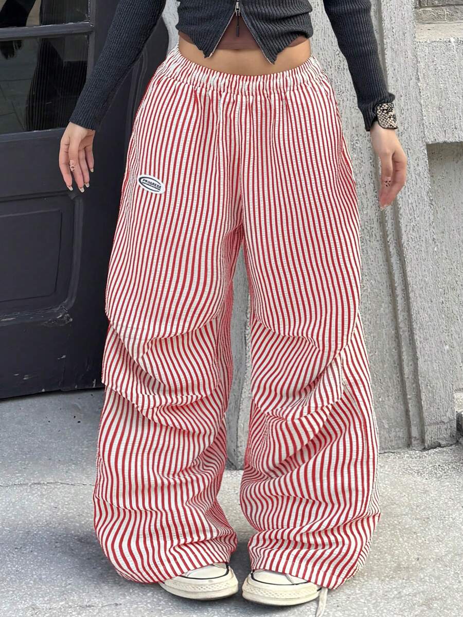 Women's black and white striped wide leg pants featuring an elastic drawstring waistband, side pockets, and a loose straight leg fit.