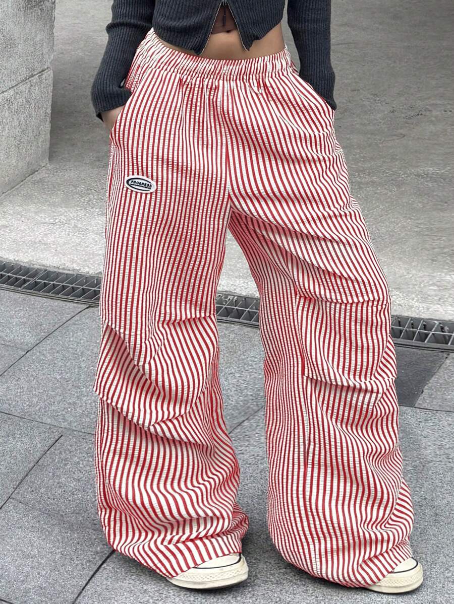 Women's black and white striped wide leg pants featuring an elastic drawstring waistband, side pockets, and a loose straight leg fit.