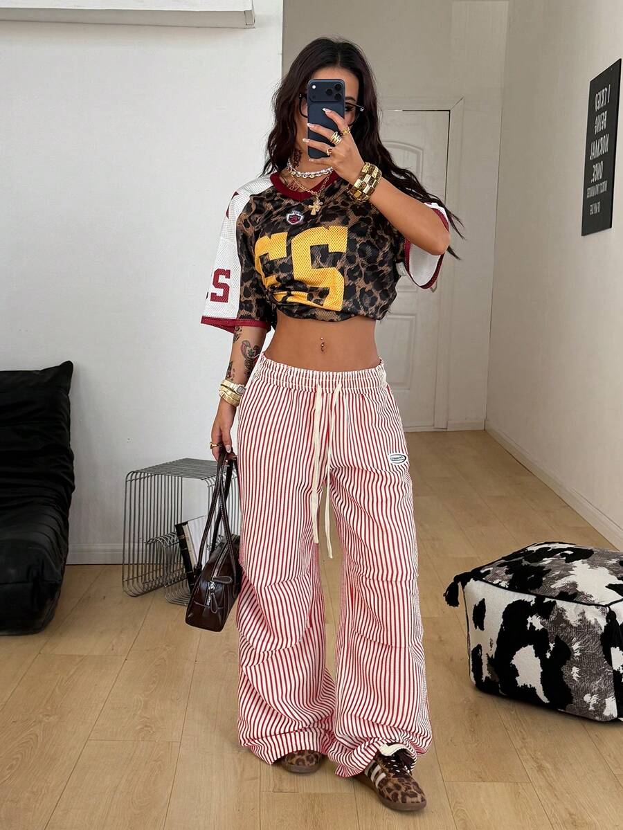 Women's black and white striped wide leg pants featuring an elastic drawstring waistband, side pockets, and a loose straight leg fit.