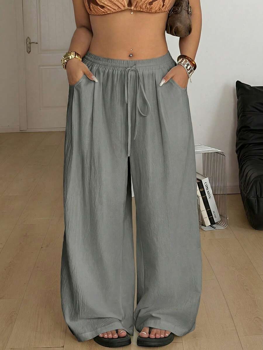 Women's loose straight leg cotton pants featuring a high waist with an adjustable drawstring knot and functional side pockets.
