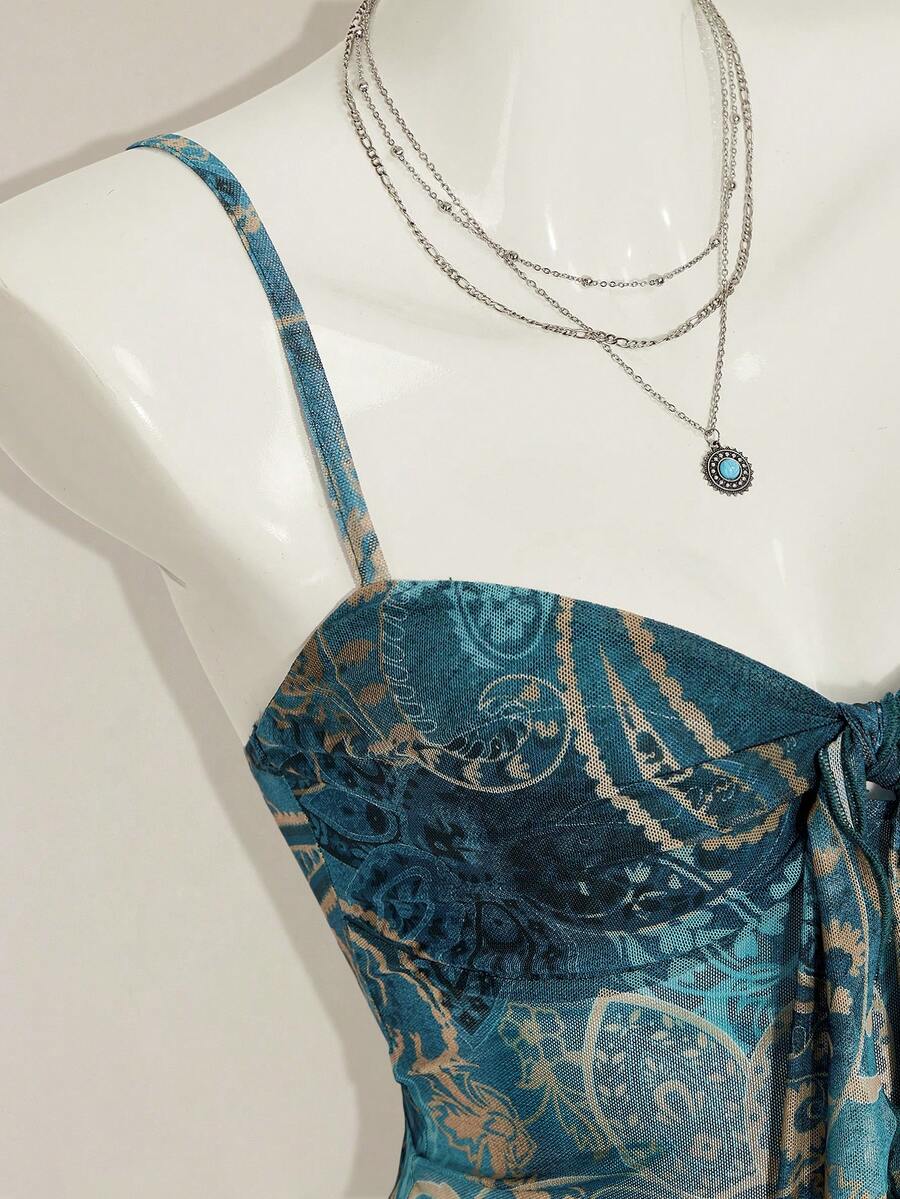 Women's green paisley print Y2K cami top with spaghetti straps, pleated styling, lace-up knot detail, and asymmetrical boho design.