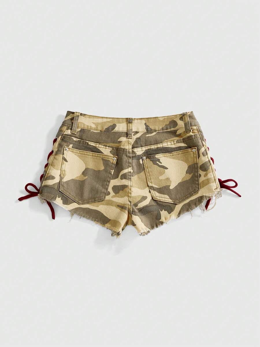 Women's Y2K low waist camo mini skort shorts featuring lace-up knot details, grommet eyelets, graphic lettering pattern, and a zipper fly.