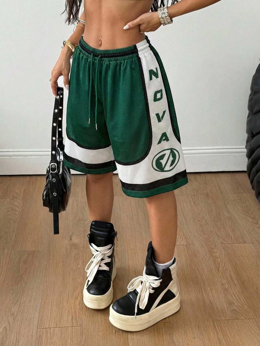 Green loose fit mesh track shorts featuring side stripes, drawstring waistband, and letter print detailing