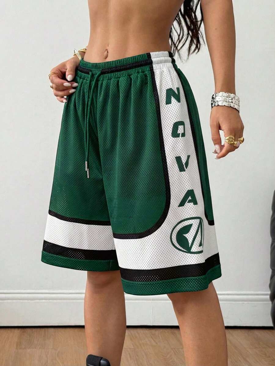 Green loose fit mesh track shorts featuring side stripes, drawstring waistband, and letter print detailing