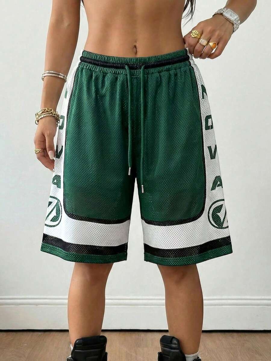 Green loose fit mesh track shorts featuring side stripes, drawstring waistband, and letter print detailing