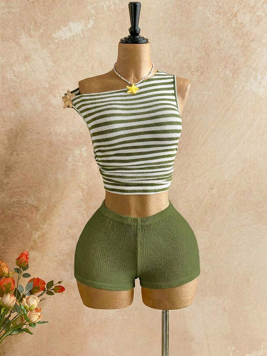 Women's black fuzzy knit two-piece set with an asymmetrical crop camisole top featuring ruched detail and cutout back, paired with matching mini shorts.