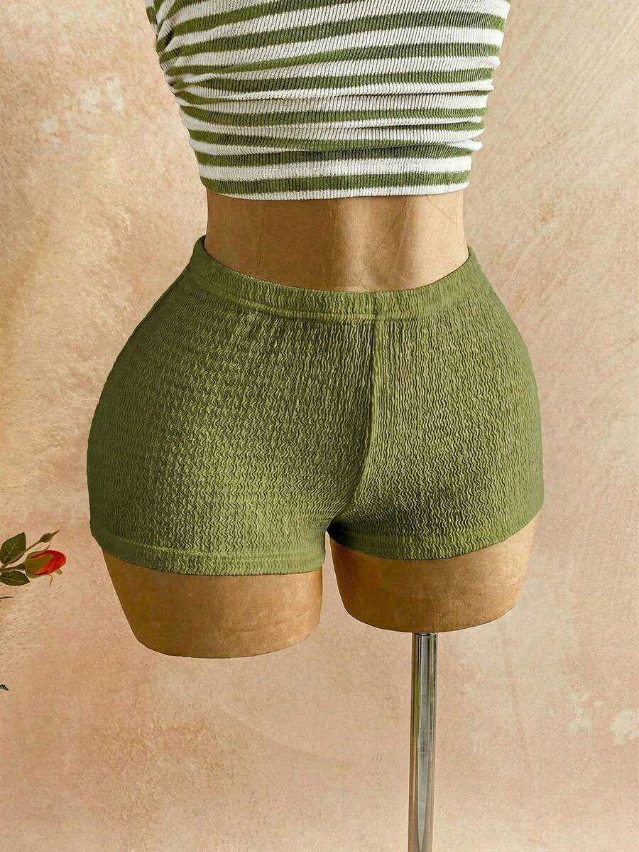 Women's black fuzzy knit two-piece set with an asymmetrical crop camisole top featuring ruched detail and cutout back, paired with matching mini shorts.