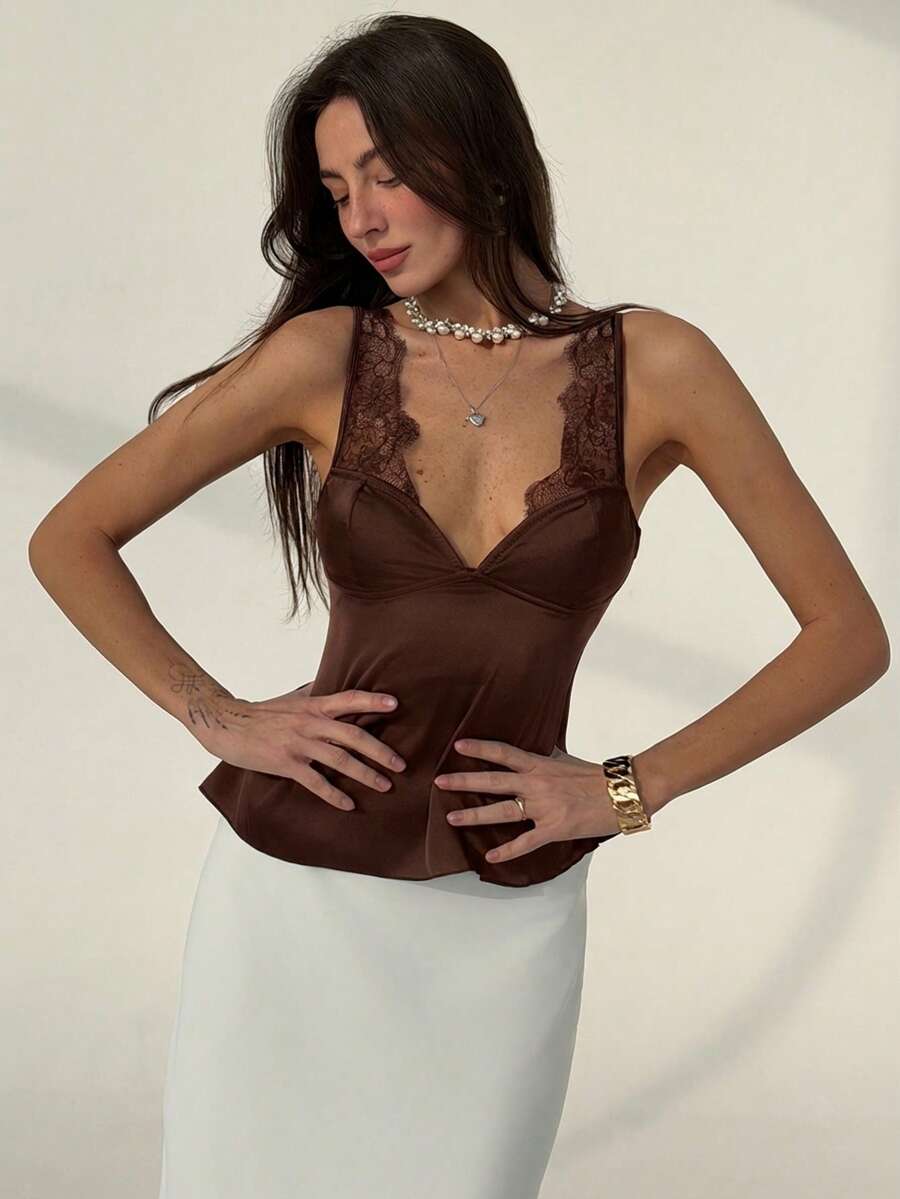 Women's black contrast lace tank top featuring a backless design, asymmetrical hem, and delicate spaghetti straps.