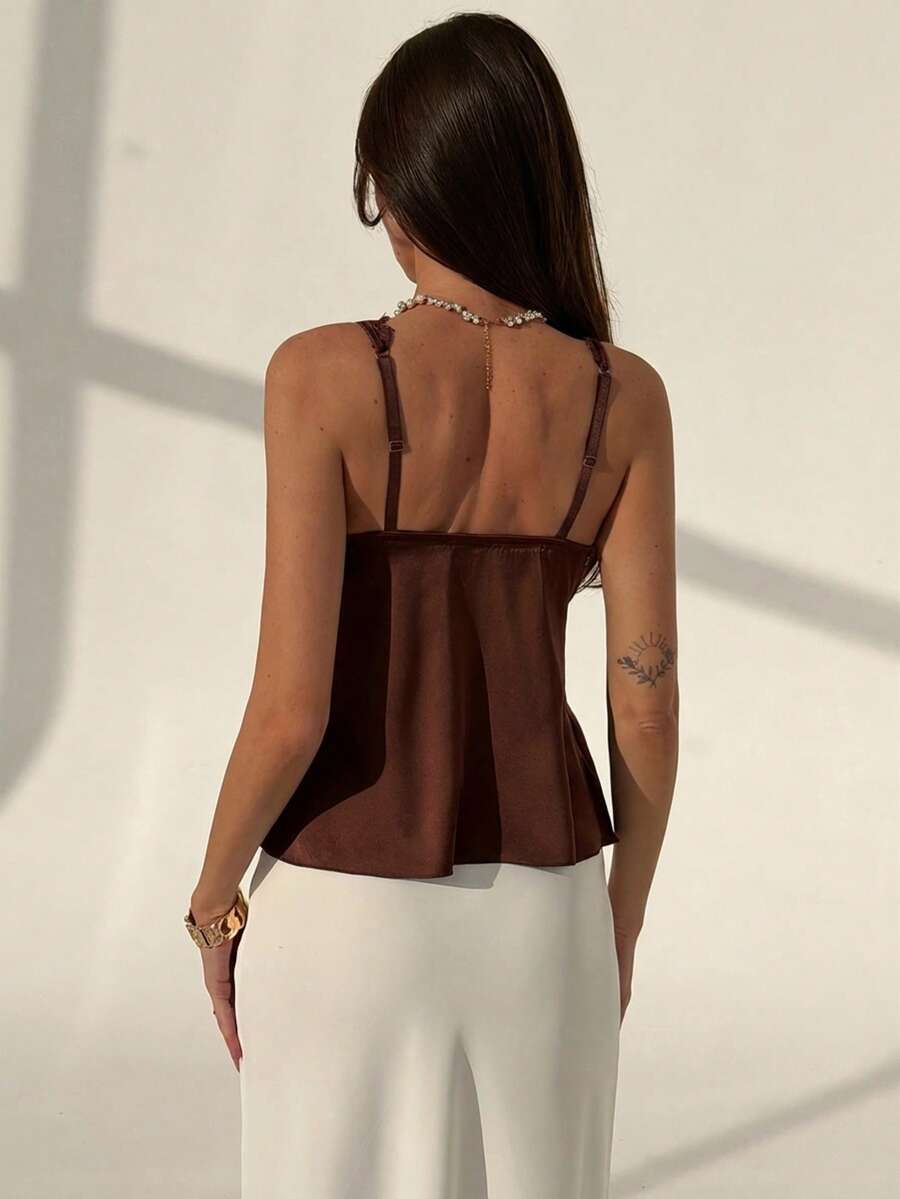 Women's black contrast lace tank top featuring a backless design, asymmetrical hem, and delicate spaghetti straps.