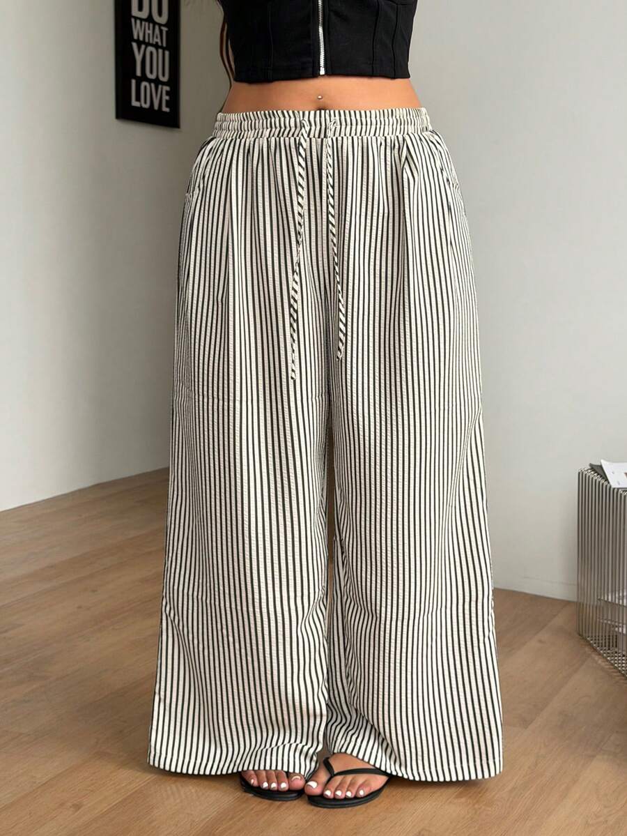 Plus size women's striped loose straight leg cropped pants with pleated detailing and side pockets