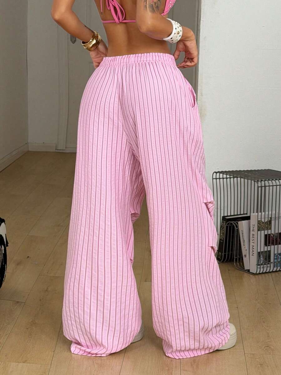 Women's black and white striped wide leg pants featuring an elastic drawstring waistband, side pockets, and a loose straight leg fit.