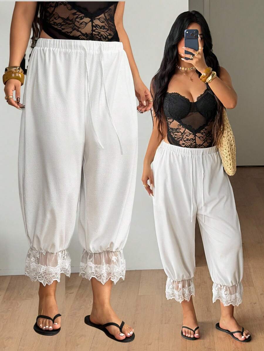 Women's loose-fitting lantern bloomer pants in capri length featuring delicate contrast lace trim and a drawstring waist.