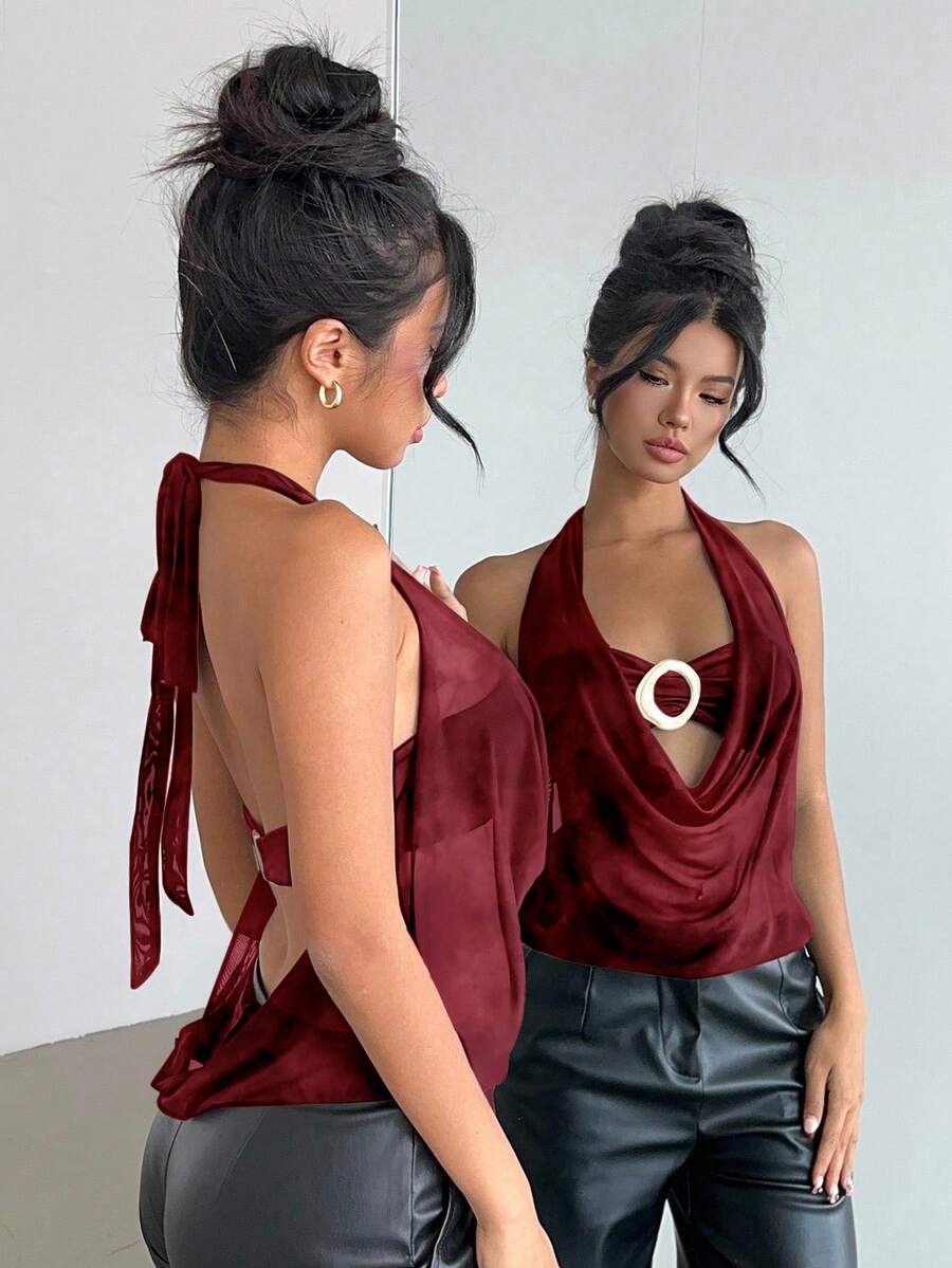 Brown and white polka dot semi-sheer halter camisole top with a plunging neckline, backless design, draped front, and metallic studded embellishments.