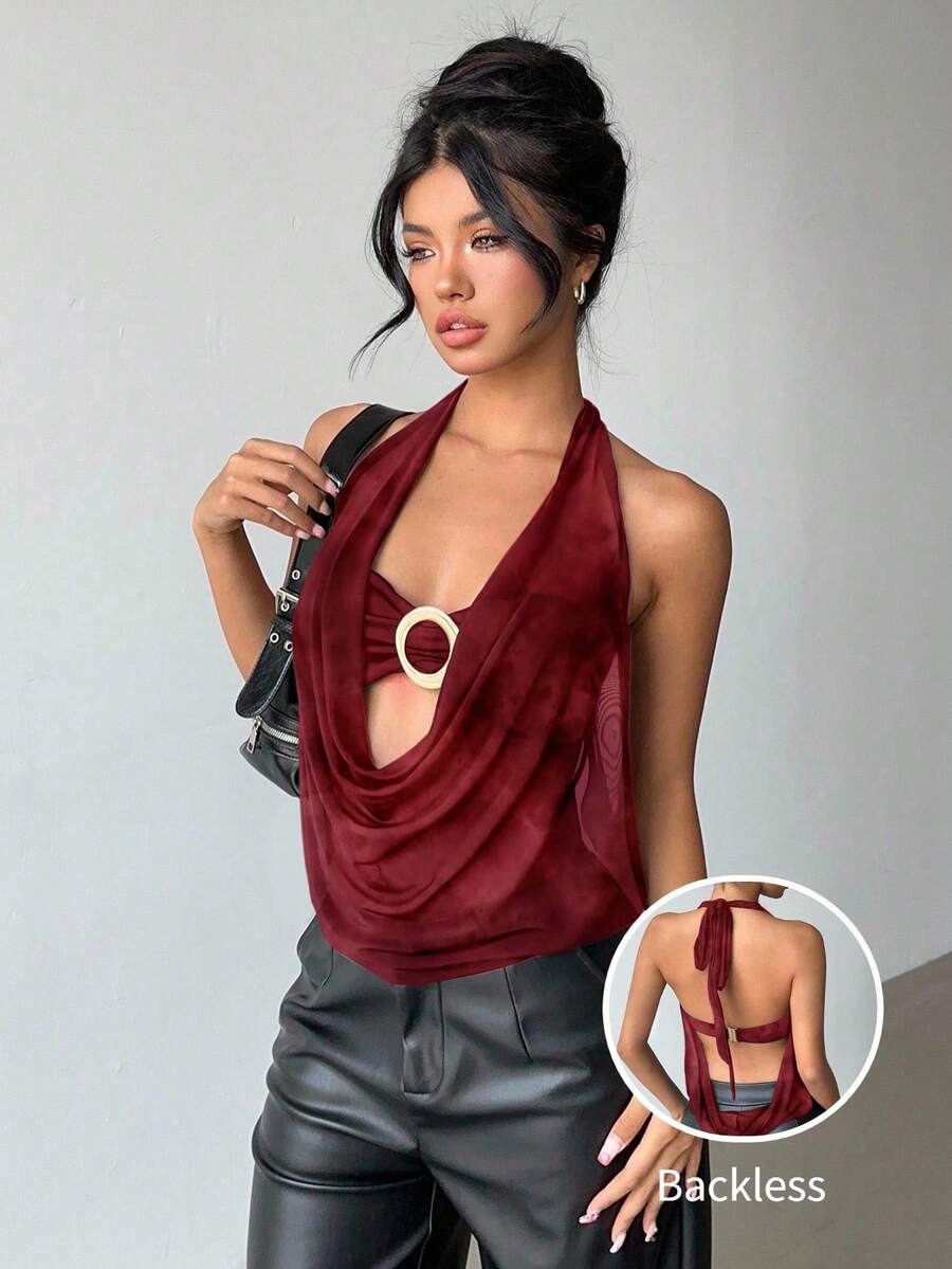 Brown and white polka dot semi-sheer halter camisole top with a plunging neckline, backless design, draped front, and metallic studded embellishments.