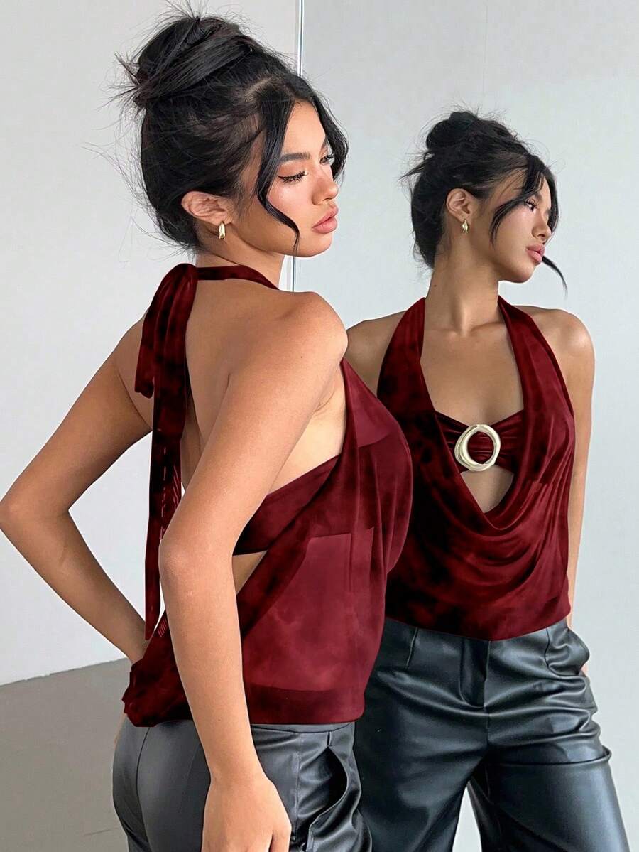 Brown and white polka dot semi-sheer halter camisole top with a plunging neckline, backless design, draped front, and metallic studded embellishments.