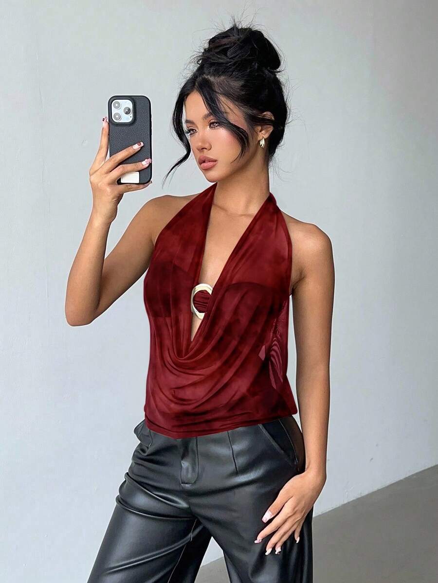 Brown and white polka dot semi-sheer halter camisole top with a plunging neckline, backless design, draped front, and metallic studded embellishments.