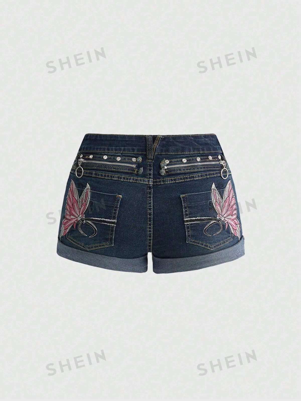 Blue washed shorts with butterfly embroidery, distressed detailing, ultra low waist, button closure, zipper fly, and pockets.