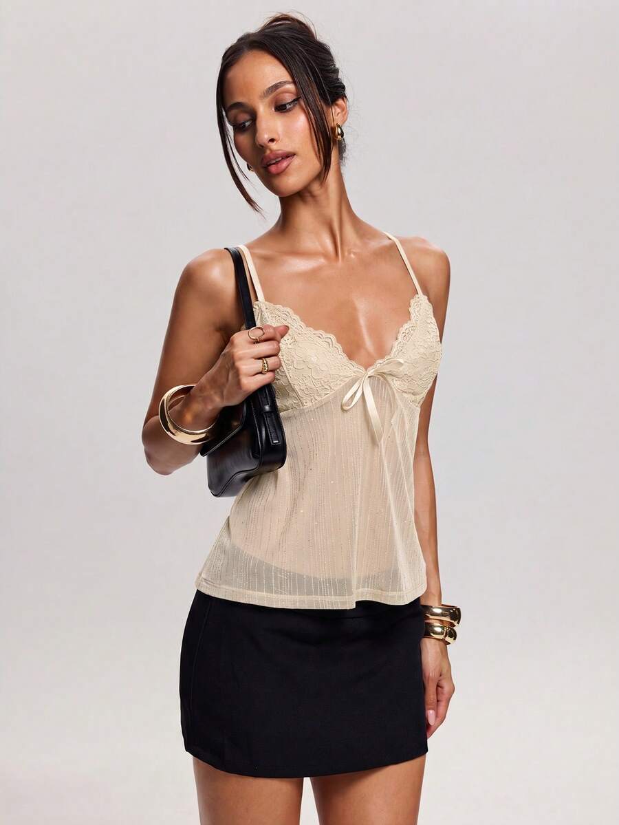 Women's backless spaghetti strap camisole top featuring contrast lace details, knot accents, and a slim fit.
