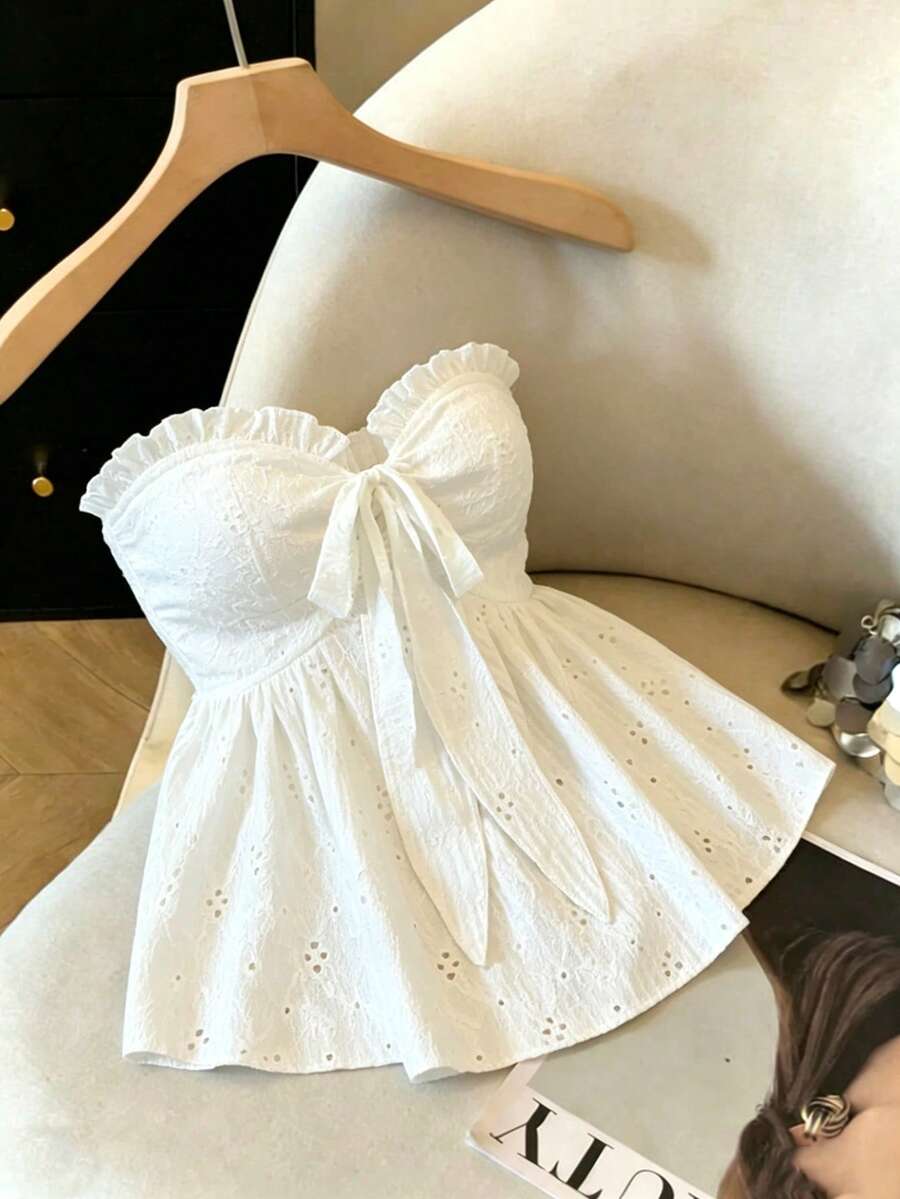 Elenzga white knitted sleeveless camisole top featuring spaghetti straps, front bow detail, hollow-out waist, and frill trim hem.