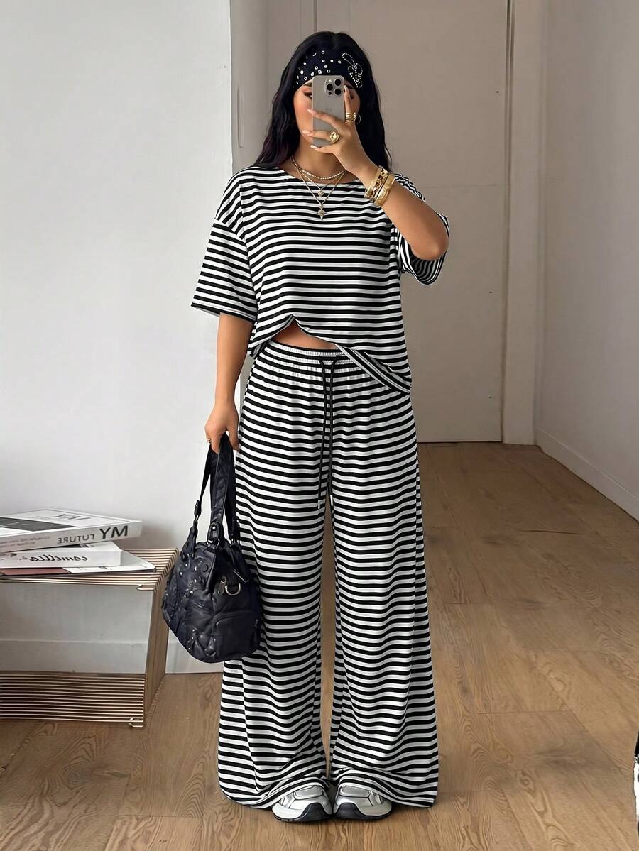 Women's casual two-piece outfit featuring a loose short-sleeve asymmetrical neck t-shirt and matching long wide leg pants with pockets.