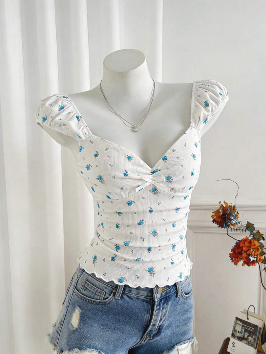 Women's short sleeve knit top with a sweetheart neckline and ruched twist knot front detail.